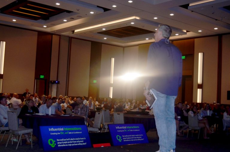 Joe Hammer delivering a high-energy keynote presentation at a business conference